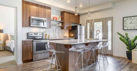 a kitchen with wooden cabinets and a large island with a breakfast bar