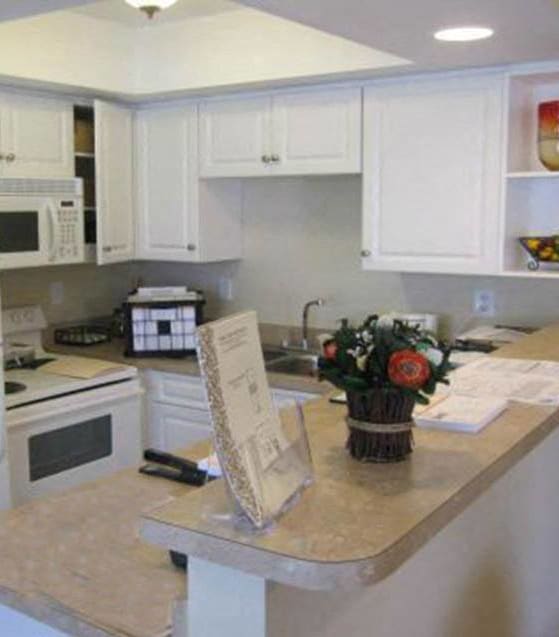 a white kitchen with a counter and a refrigerator