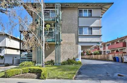a street view of an apartment building with stairs on the side of it