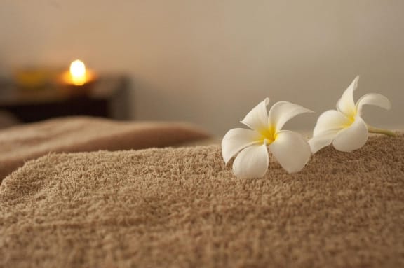 a massage bed with a white flower on it