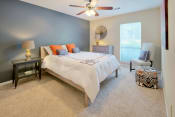 Thumbnail 22 of 32 - Columbus Luxury Apartments For Rent - Spacious Bedroom With Ceiling Fan, Carpet Flooring, And A Large Window With Blinds.