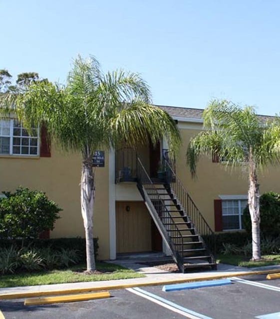 a yellow building with palm trees in front of it