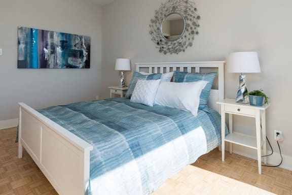 a bedroom with a bed with a blue and white comforter
