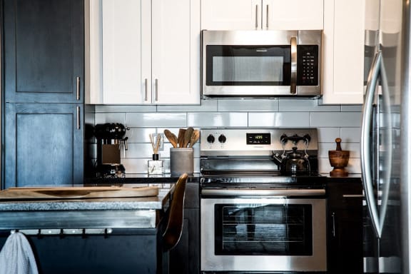 a kitchen with a stove and a microwave at CityWay Apartments, Indianapolis