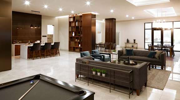 A billiard table is in the middle of a spacious living room.
