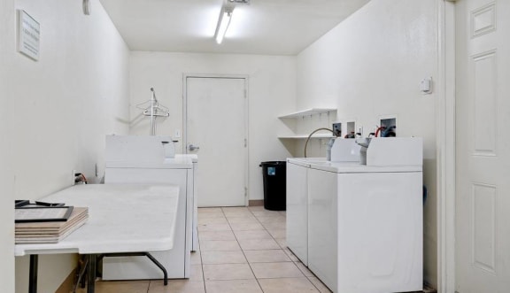 a room with two washing machines and a table  at ReNew Eagle River, Alaska, 99577