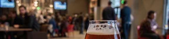 a glass of beer sitting on a wooden table at Parcels at Concourse, Memphis, 38104