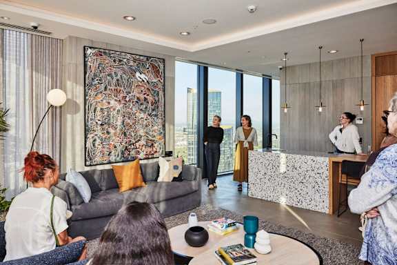 A group of people are gathered in a modern living room.
