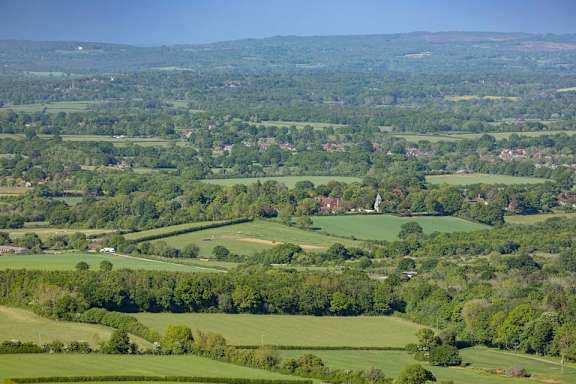 a view of the countryside with green fields and trees