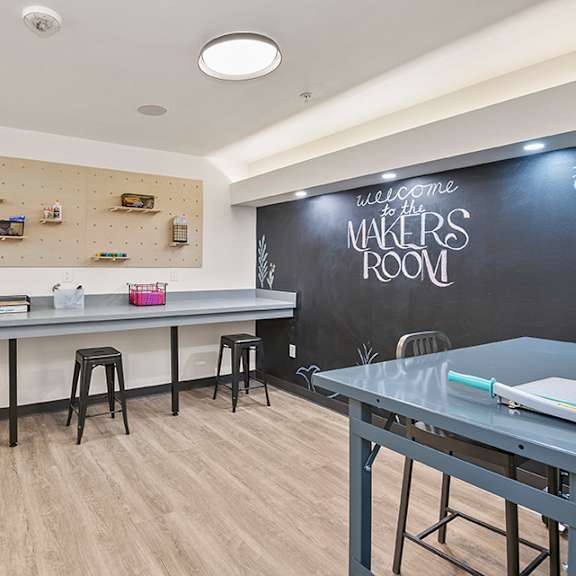a room with a chalkboard wall and a long table with stools