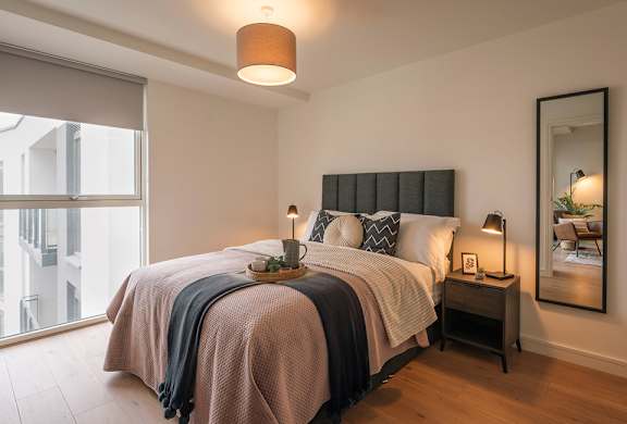 A bedroom with a large bed and a large window.