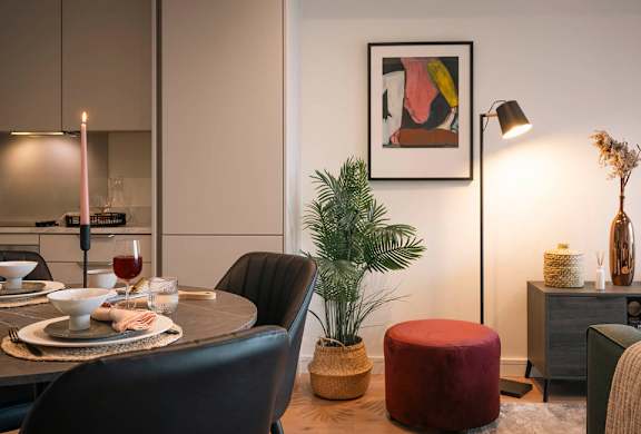 A modern dining room with a round table set for two.