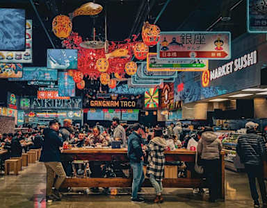 a crowded restaurant with people standing around a bar