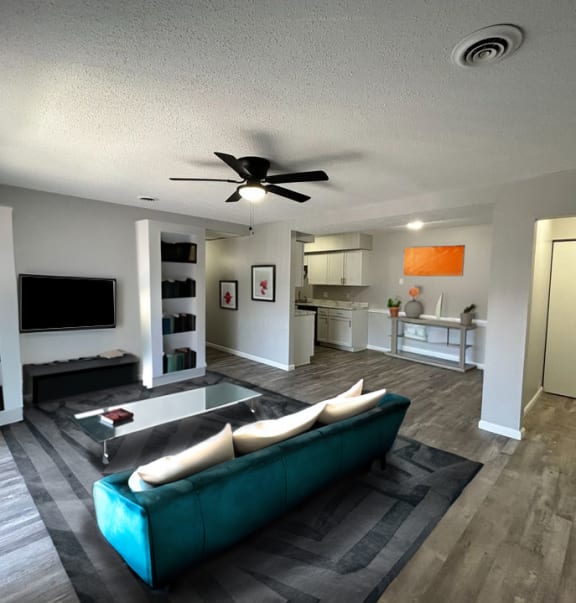 a living room filled with furniture and a ceiling fan