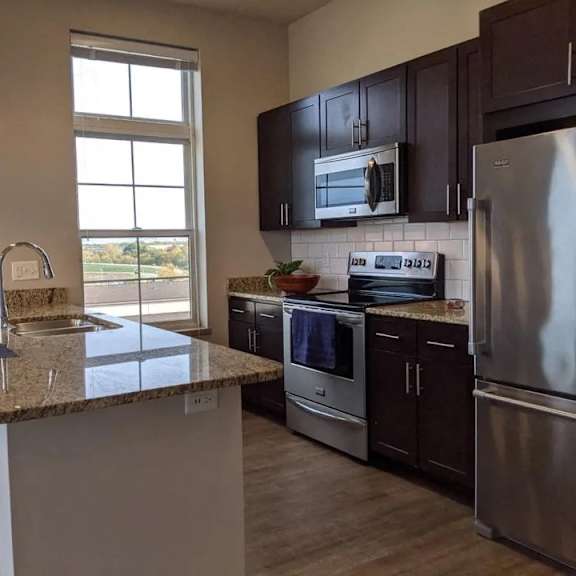 A kitchen with granite countertops and stainless steel appliances.