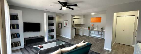 a living room filled with furniture and a ceiling fan