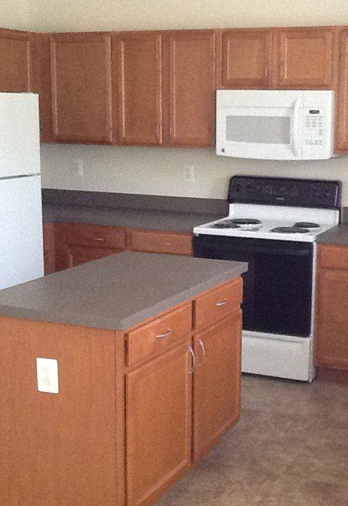 A kitchen with brown cabinets and a white fridge.