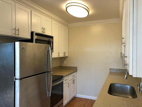 A kitchen with white appliances and cabinets.