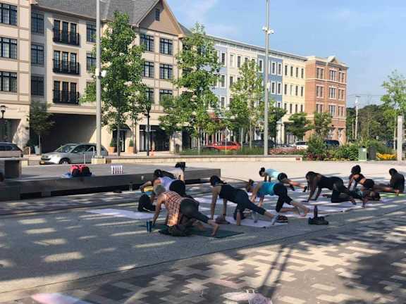 A group of people are practicing yoga on the street.