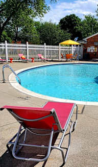 a resort style pool with lounge chairs and umbrellas