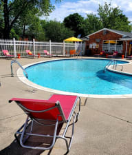 a resort style pool with lounge chairs and umbrellas