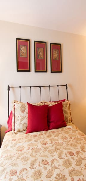 a bedroom with a bed and dressers and a mirror at The Summit at Owings Mills Apartments, Owings Mills, MD 21117