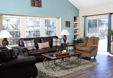 a living room with a blue wall and leather couches and chairs