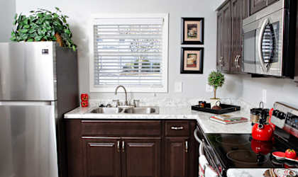 a kitchen with dark wood cabinets and white countertops