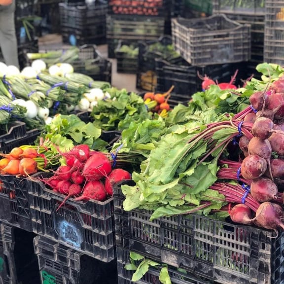a variety of vegetables in crates at a market