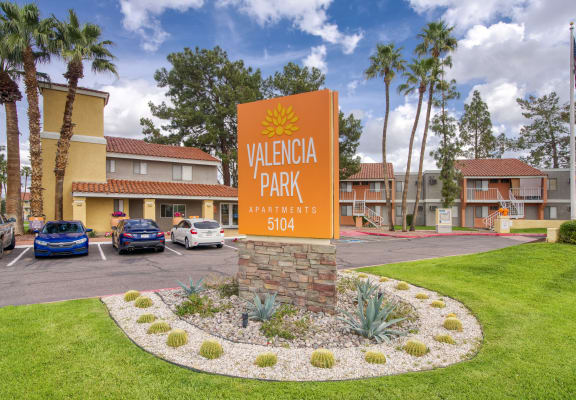 a parking lot with a sign that reads valencia park apartments