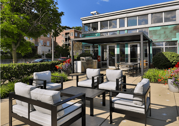 A patio with a table and chairs is in front of a building.