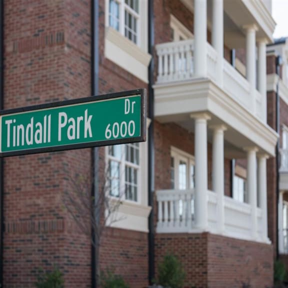 Street sign for Tindall Park Drive in front of a brick building.