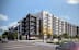 A modern apartment building with a mix of black and white and yellow accents.
