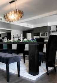 A modern dining room with a black table and chairs.