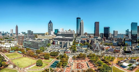 A cityscape with tall buildings and a clear blue sky.
