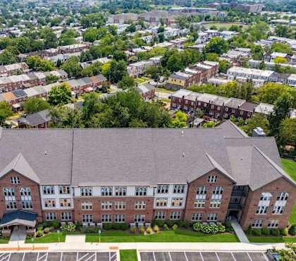 A large brick building with a parking lot in front.