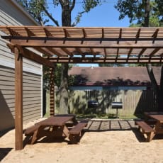 a pergola over a picnic table in a backyard