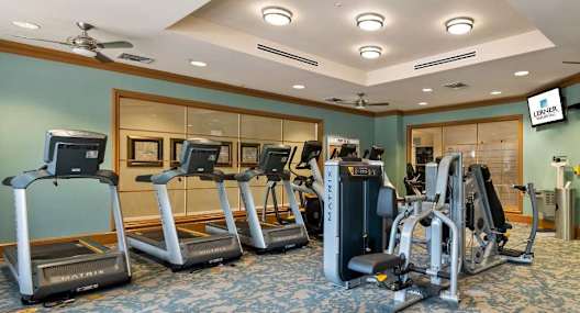 A gym with treadmills, elliptical machines, and other exercise equipment.