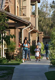 A woman and a child are walking down a sidewalk.