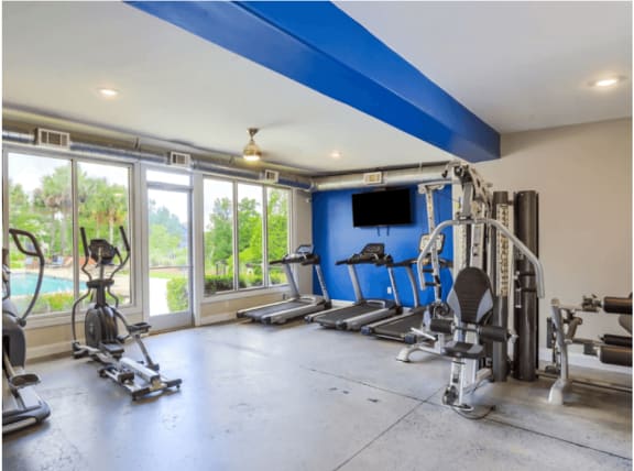 a home gym with a blue accent wall and a large window