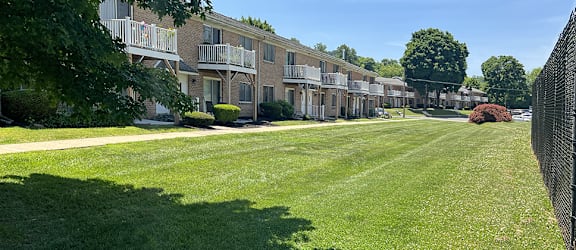 A row of apartment buildings with green lawns in front.