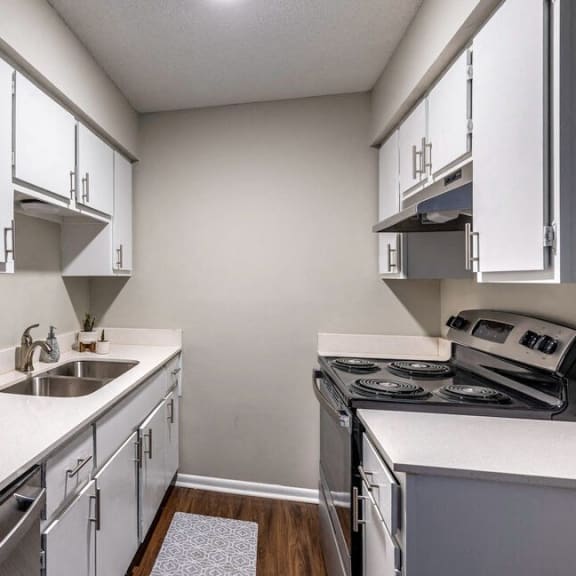 an empty kitchen with white cabinets and stainless steel appliances