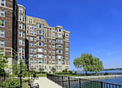 Thumbnail 8 of 66 - Alden Towers apartment building sitting alongside the Detroit River with sidewalk paths.