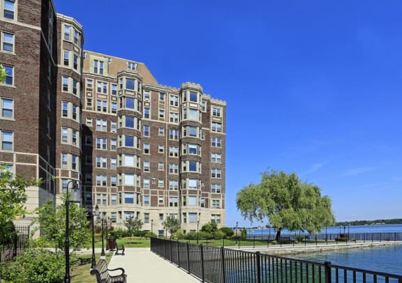 Alden Towers apartment building sitting alongside the Detroit River with sidewalk paths.