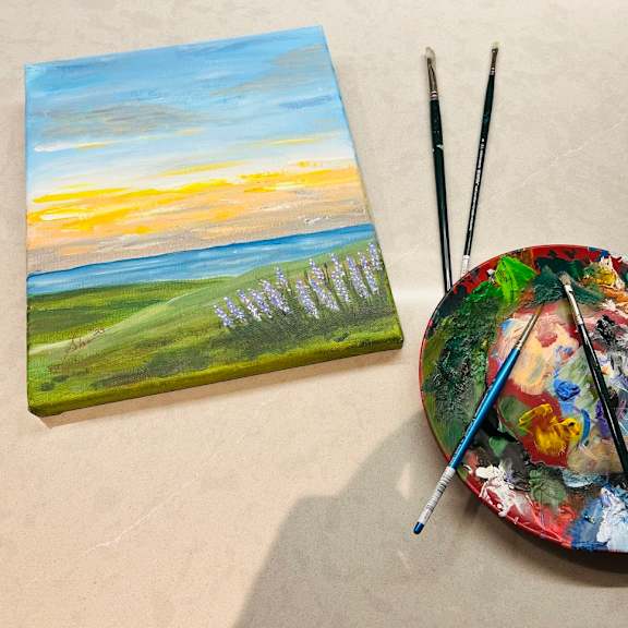 A painting of a sunset over a field with a palette and paintbrushes at Cherrywood Apartments, D18 VY3V, DUBLIN 18