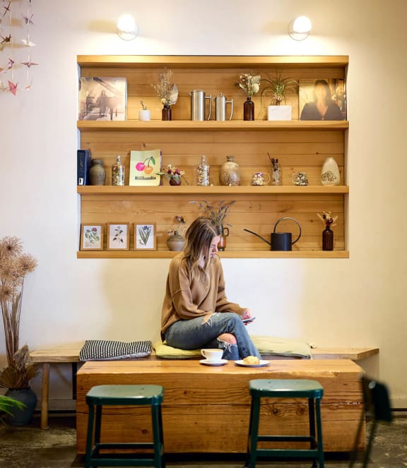 a woman sitting on a table in a coffee shop