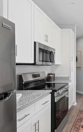 an open kitchen with a granite counter top and stools