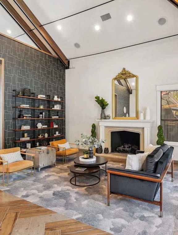 A living room with a fireplace and a mirror above it.