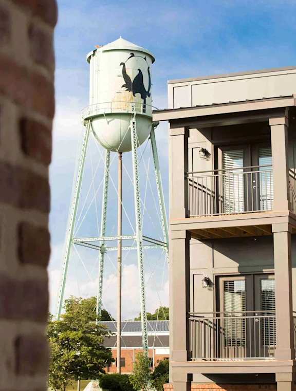A building with the number 1000 on it has a water tower in front of it.