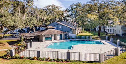 A house with a pool surrounded by a fence.